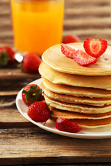Delicious pancakes with strawberry on brown wooden background