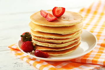 Delicious pancakes with strawberry on white wooden background