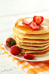 Delicious pancakes with strawberry on white wooden background