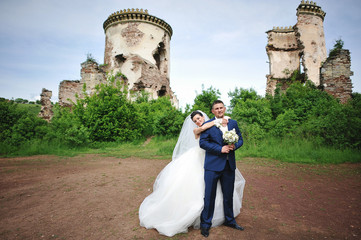 beautiful wedding couple near ruins tower of old castle