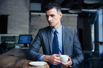 Pensive businessman drinking coffee in cafe