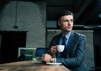 Pensive businessman drinking coffee in cafe