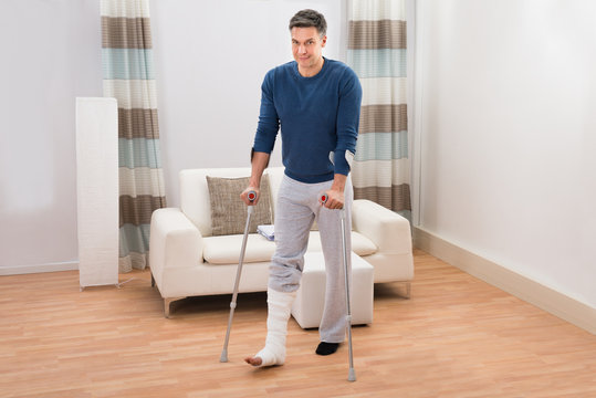 Disabled Man Using Crutches For Walking