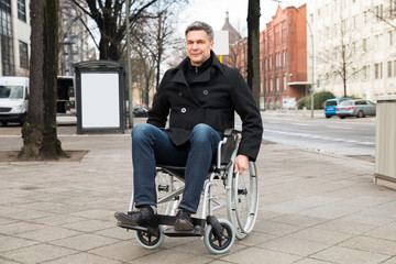 Disabled Man On Wheelchair In City