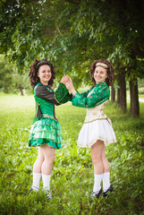 Two young beautiful girl in irish dance dress posing outdoor