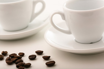 Tazzine di caffè vuote con piattino e grani di caffè