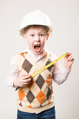 Boy in a helmet with a tape measure and emotionally shouts