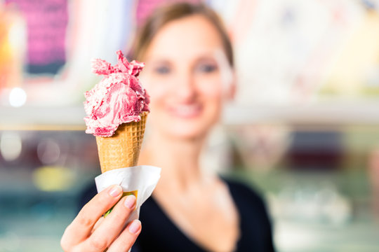 Eisverk&auml;uferin portioniert Kugel Eiscreme in Waffel
