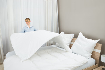Female Housekeeping Worker Making Bed