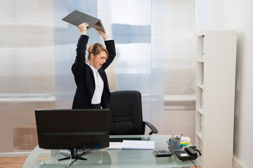 Angry Businesswoman Throwing Laptop