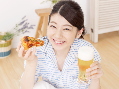ピザとビールを持つ女性