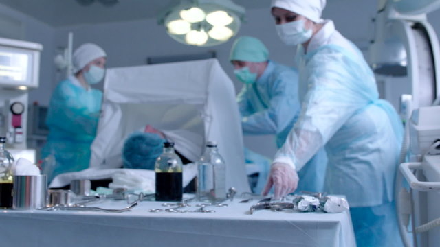 Nurse Giving a Tissue Forceps to Surgeon