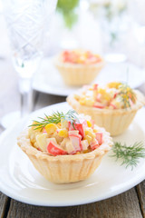 Mini tarts with crab meat and sweet corn salad on festive table