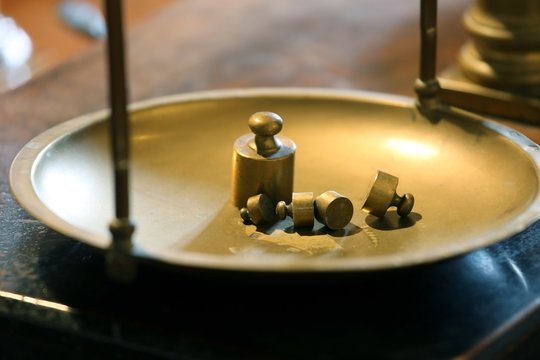 ancient brass precision scales with weights above the balance Pa