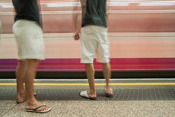 Fototapeta na wymiar Commuters on platform, motion blur as train arrives.