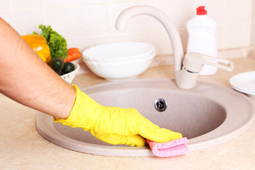 Male hand in gloves with sponge washing washbasin