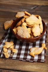 Cookies in bowl on brown wooden background