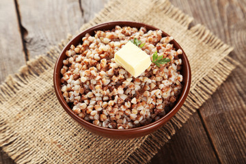 Buckwheat in bowl on brown wooden background