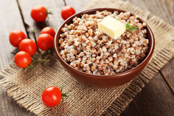 Buckwheat in bowl on brown wooden background
