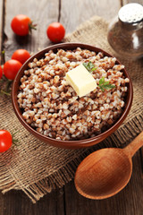 Buckwheat in bowl on brown wooden background