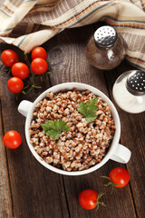 Buckwheat in bowl on brown wooden background