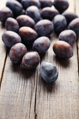 Fresh plums on brown wooden background