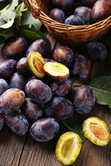 Fresh plums on brown wooden background