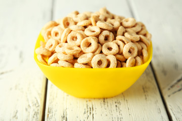 Bowl of cornflakes on white wooden background