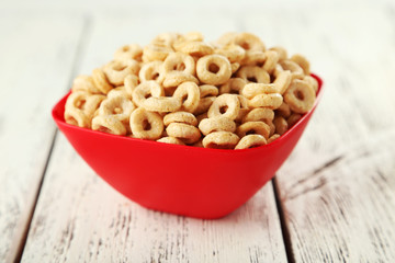 Bowl of cornflakes on white wooden background