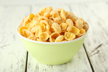 Bowl of cornflakes on white wooden background