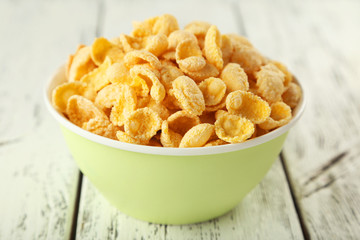 Bowl of cornflakes on white wooden background