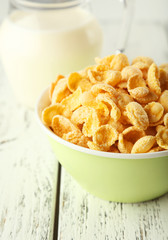 Bowl of cornflakes on white wooden background