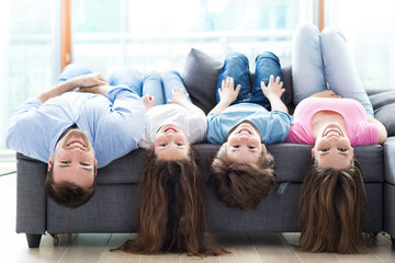 Family lying upside down on sofa

