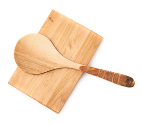 Wooden spoon over the cutting board isolated