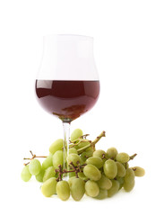 Glass of red wine next to a branch of grapes