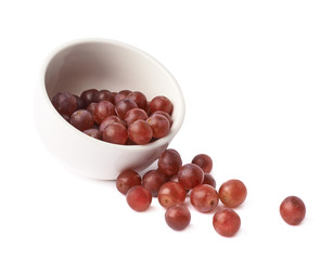 Dark red grapes spilled out of bowl