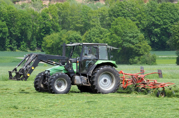 Traktor beim Heuwenden