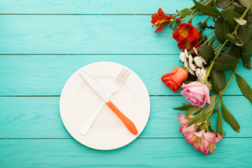 Romantic dinner with flowers on blue wooden table at the restaurant. Top view