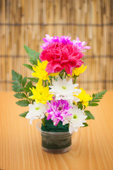 Fototapeta na wymiar Colorful flower bouquet arrangement in vase on wood background