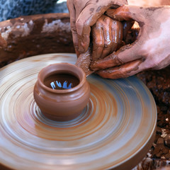 Hands working on pottery wheel