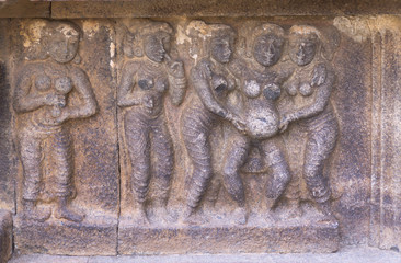 Mural sculpture of standing-up birthing scene.
