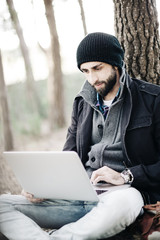 Urban man work on computer at the forest