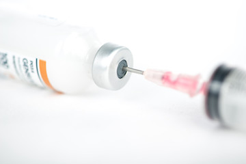 Injection preparation with vial and syringe on white