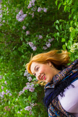 Young woman in motion on the background of blooming lilacs, spar