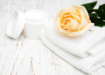 Fototapeta na wymiar Rose with moisturiser cream and towels