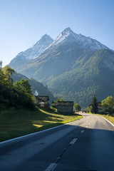 Fototapeta premium Alps Road Lined with Houses in Swiss, Valais, Alps.