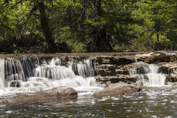 Fototapeta na wymiar Fluss mit Wasserfall in einem Wald