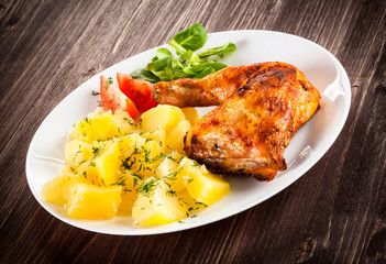 Barbecued chicken leg with boiled potatoes and vegetables