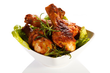 Grilled chicken legs and vegetables on white background 