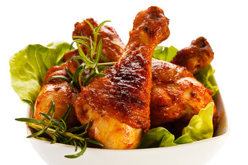 Grilled chicken legs and vegetables on white background 